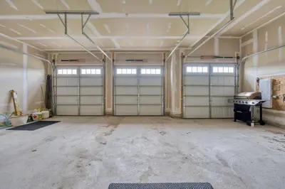 an empty room with two garage doors in a building at Spacious & New Prince Edward County Villa in Carrying Place