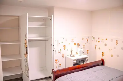 a bedroom with a bed and a desk and shelves at Oshawa Two Bedroom Private Suite in Oshawa
