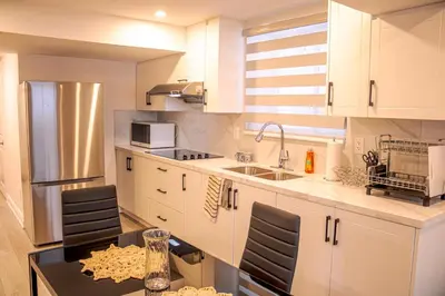 a kitchen with white cabinets and a black table at Oshawa Two Bedroom Private Suite in Oshawa