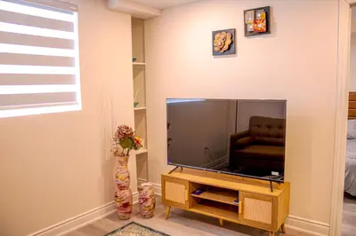 a living room with a television and a chair at Oshawa Two Bedroom Private Suite in Oshawa