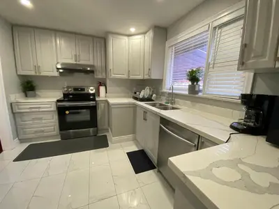 a kitchen with white cabinets and a stove at Adorable 3 private rooms- main with free parking in Toronto