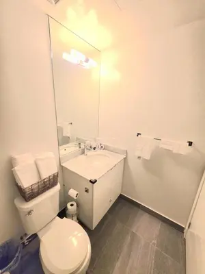 a bathroom with a toilet and a sink and a mirror at Amazing one bedroom suite with panoramic downtown views in Toronto
