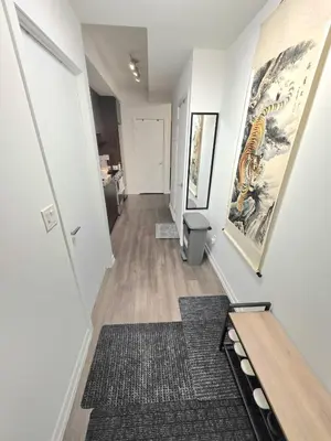 a hallway with white walls and a hallway with a rug at Amazing one bedroom suite with panoramic downtown views in Toronto