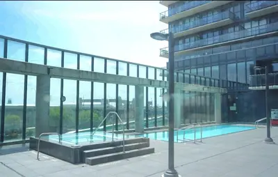 a building with a swimming pool in front of a building at Amazing one bedroom suite with panoramic downtown views in Toronto