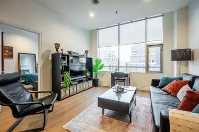 a living room with a couch and a tv at The Artist Loft Trendy 2BR Condo with Parking in Toronto
