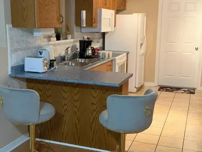 a kitchen with two chairs and a counter with a sink at Cozy Private Basement Apartment in Fort Erie in Fort Erie