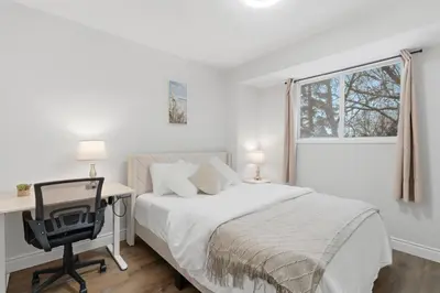 a bedroom with a bed and a desk and a window at Waterloo Paradise with Rec room, Workspace, Park and close to St Jacobs Market in Waterloo