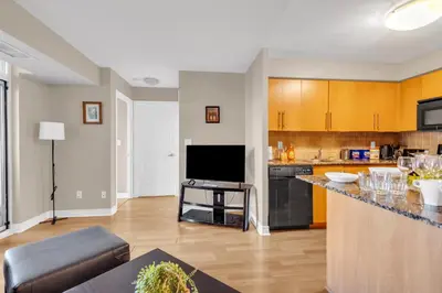 a living room with a kitchen with a counter top at 2 bedroom spacious apartment in Mississauga in Mississauga