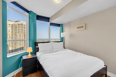 a bedroom with a bed and two windows at 2 bedroom spacious apartment in Mississauga in Mississauga