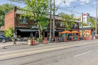 a building with orange umbrellas on a city street at Picturesque 3-story townhouse in Toronto