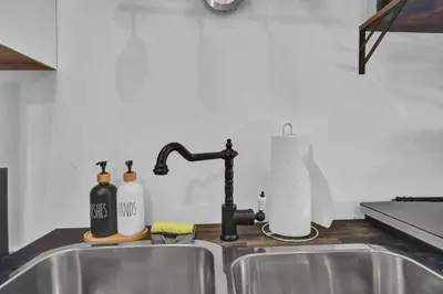 a kitchen sink with a faucet and bottles on it at Spacious 1 bed 1 bath Apt Close to Downtown and Beach in Cobourg