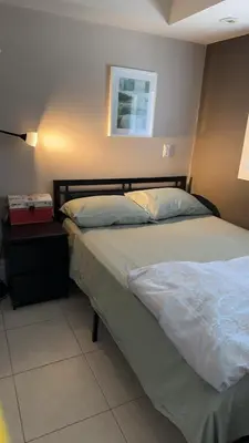 a bedroom with a bed and a picture on the wall at Comfortable Basement Private Room with Ensuite Near Plaza in Richmond Hill