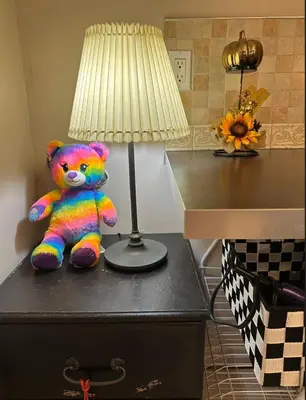 a teddy bear sitting on a table next to a lamp at Comfortable Basement Private Room with Ensuite Near Plaza in Richmond Hill