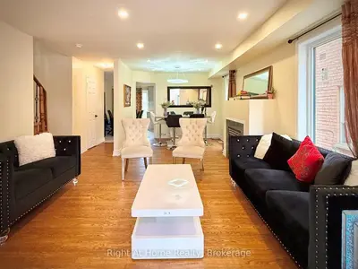 a living room with a black couch and a table at 3409 McDowell Drive Mississauga Ontario L5M6R7 in Mississauga