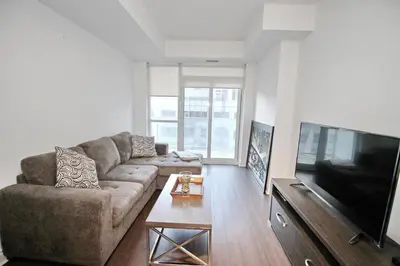 a living room with a couch and a flat screen tv at The Grand Avenue Suites - Downtown Toronto Entertainment District in Toronto