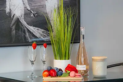 a table with two glasses and a bottle of wine at Welcome To Our Modern 2Bdrm,1Bth w, Laundry,BBQ in Welland