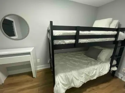 a black bunk bed in a room with a mirror at Welcome To Our Modern 2Bdrm,1Bth w, Laundry,BBQ in Welland