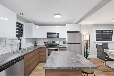 a kitchen with white appliances and a marble counter top at Welcome To Our Modern 2Bdrm,1Bth w, Laundry,BBQ in Welland