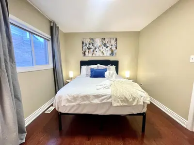 a bedroom with a bed with white sheets and a window at Maison Laurier, Modern 5B4B Home Inc BSMT Free parking, Close to trails in Richmond Hill