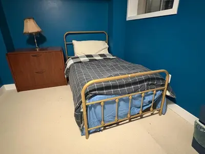 a bed in a room with a blue wall at Sunshine room on Downsview in Toronto