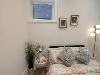 a bedroom with a bed and a window and a mirror at Luxury 1BR plus den walkout basement in Toronto