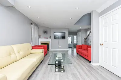 a living room with two red couches and a fireplace at Entire 4BR 3BA Home in Mississauga, Sleeps 8, 10 mins to Pearson Airport in Mississauga