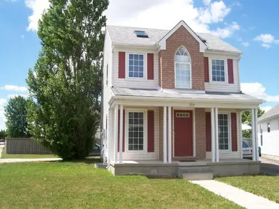 a house with a red door in a yard at Lakeshore North - Waterloo, Ontario in Waterloo
