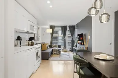 a kitchen and living room with a table and a couch at Upscale King Suite Near CN Tower with Free Parking in Toronto