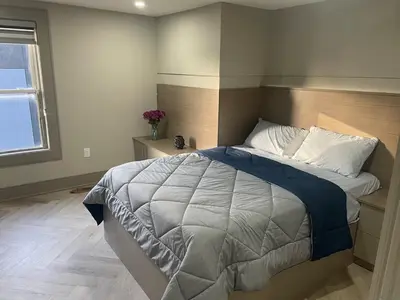 a bedroom with a large bed and a window at Modern 7 Bedroom Masterpiece on Portage Sleeps 16 in Niagara Falls