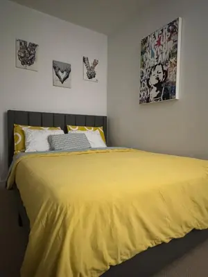 a bedroom with a large yellow bed with pictures on the wall at Skyline Suite 1-Bed Penthouse in heart of Downtown Toronto in Toronto
