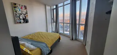 a bedroom with a bed in a room with windows at Skyline Suite 1-Bed Penthouse in heart of Downtown Toronto in Toronto