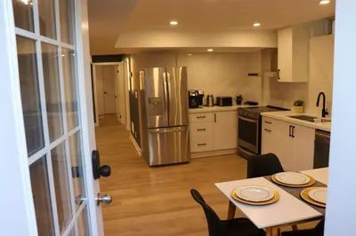 a kitchen with a table and a stainless steel refrigerator at Luxury Brand-New Spacious Apartment in Richmond Hill in Richmond Hill