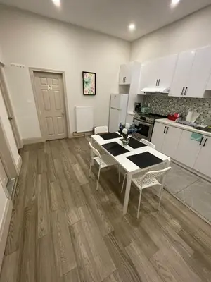 a kitchen with white cabinets and a table and chairs at Toronto Downtown Holiday Home-Private Patio,Free Wifi & Self Checkin in Toronto