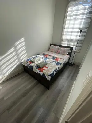 a bedroom with a bed in a room with a window at Toronto Downtown Holiday Home-Private Patio,Free Wifi & Self Checkin in Toronto