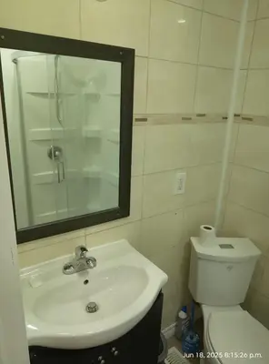 a bathroom with a sink and a mirror and a toilet at Midtown Toronto studio in Toronto