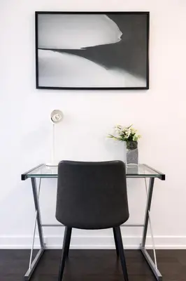 a glass desk with a chair and a picture at Fully furnished Lux 1bedroom condo in Toronto