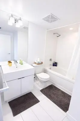 a white bathroom with a sink and a toilet at Fully furnished Lux 1bedroom condo in Toronto