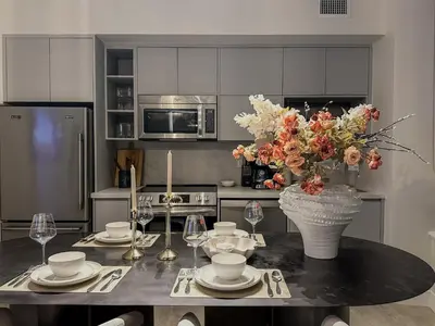 a kitchen with a table with a vase of flowers on it at 40th Fl Designer Lakeview 2BR PATH & Union Access in Toronto