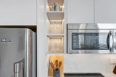 a kitchen with a stove top oven next to a refrigerator at 40th Fl Designer Lakeview 2BR PATH & Union Access in Toronto