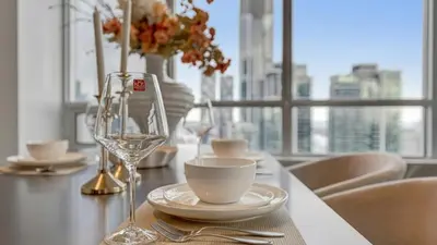 a table with a glass of wine and a bowl and a cup at 40th Fl Designer Lakeview 2BR PATH & Union Access in Toronto