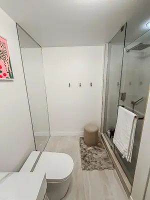 a white bathroom with a toilet and a shower at 40th Fl Designer Lakeview 2BR PATH & Union Access in Toronto