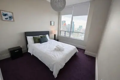 a bedroom with a bed and a large window at Luxury Penthouse with Celebration Square Views in Mississauga