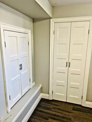 a bedroom with white doors and wood floors at Cozy Place in Oshawa
