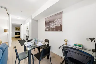 a living room with a table and chairs and a couch at Spacious Condo with 2 Beds Unbeatable Location in Toronto