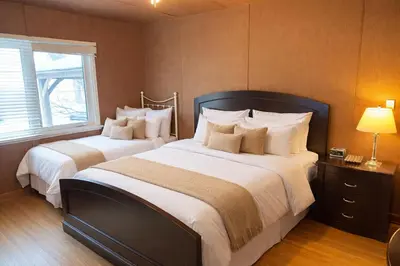a bedroom with two beds with white pillows at Private Lakehouse Getaway Hot Tub on the Water in Waubaushene
