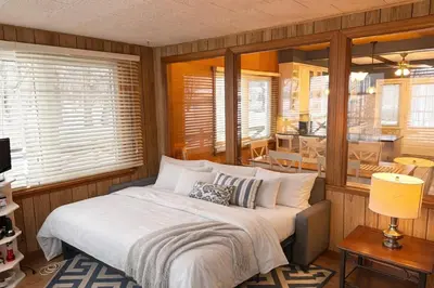 a bedroom with a bed and a dining room at Private Lakehouse Getaway Hot Tub on the Water in Waubaushene