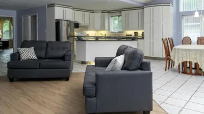 a living room with two couches and a kitchen at Muskoka 4-Bedroom Cottage in Port Carling