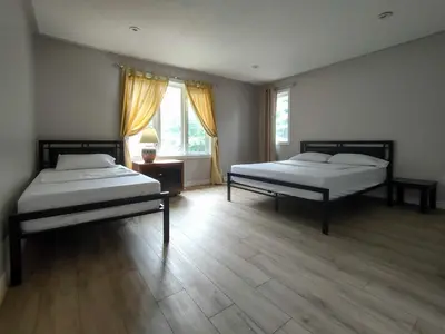 two beds in a room with two windows at Muskoka 4-Bedroom Cottage in Port Carling