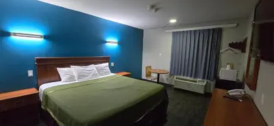 a hotel room with a bed and a blue wall at Avenue Motel in Mississauga