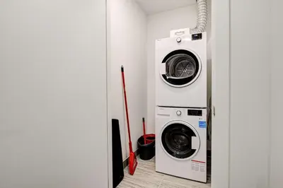 a laundry room with a washer and dryer at Stylish Downtown Suite with Patio & City Views in Kitchener